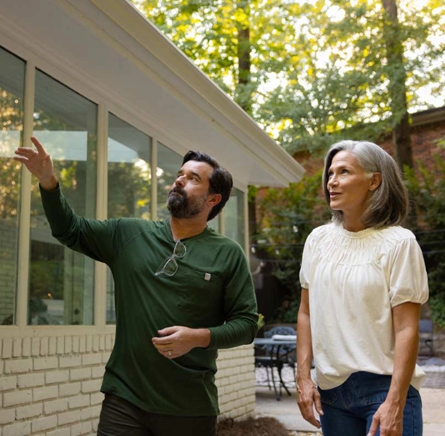 Aptive Pest Control Specialist Discussing Pest Control Solutions With A Homeowner, Pointing Out Areas Around The House That May Need Attention.