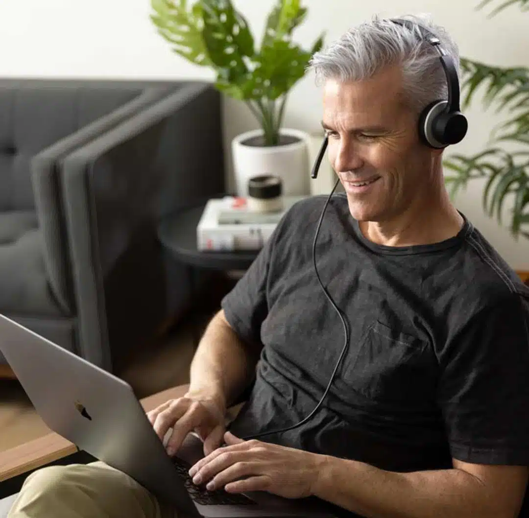 A Customer Service Representative From Aptive Pest Control, Wearing A Headset, Smiles While Assisting A Customer On A Laptop.